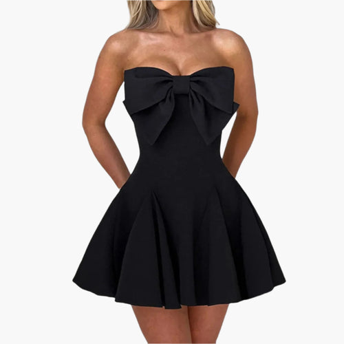 Woman wearing a black strapless mini dress with a large front bow.